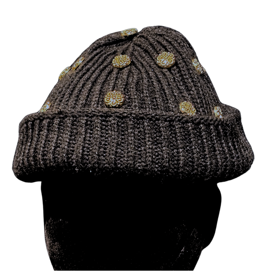 Knitted beanie with gold buttons on a white background